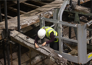Conservator measuring Mary Rose timbers on cherry picker