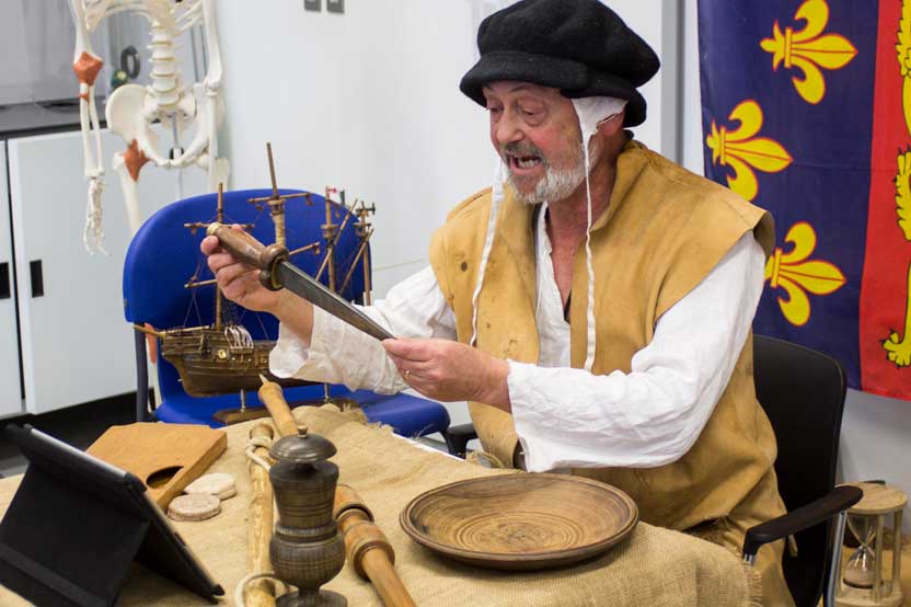 A man in Tudor costume talks about objects from the Mary Rose to a virtual audience